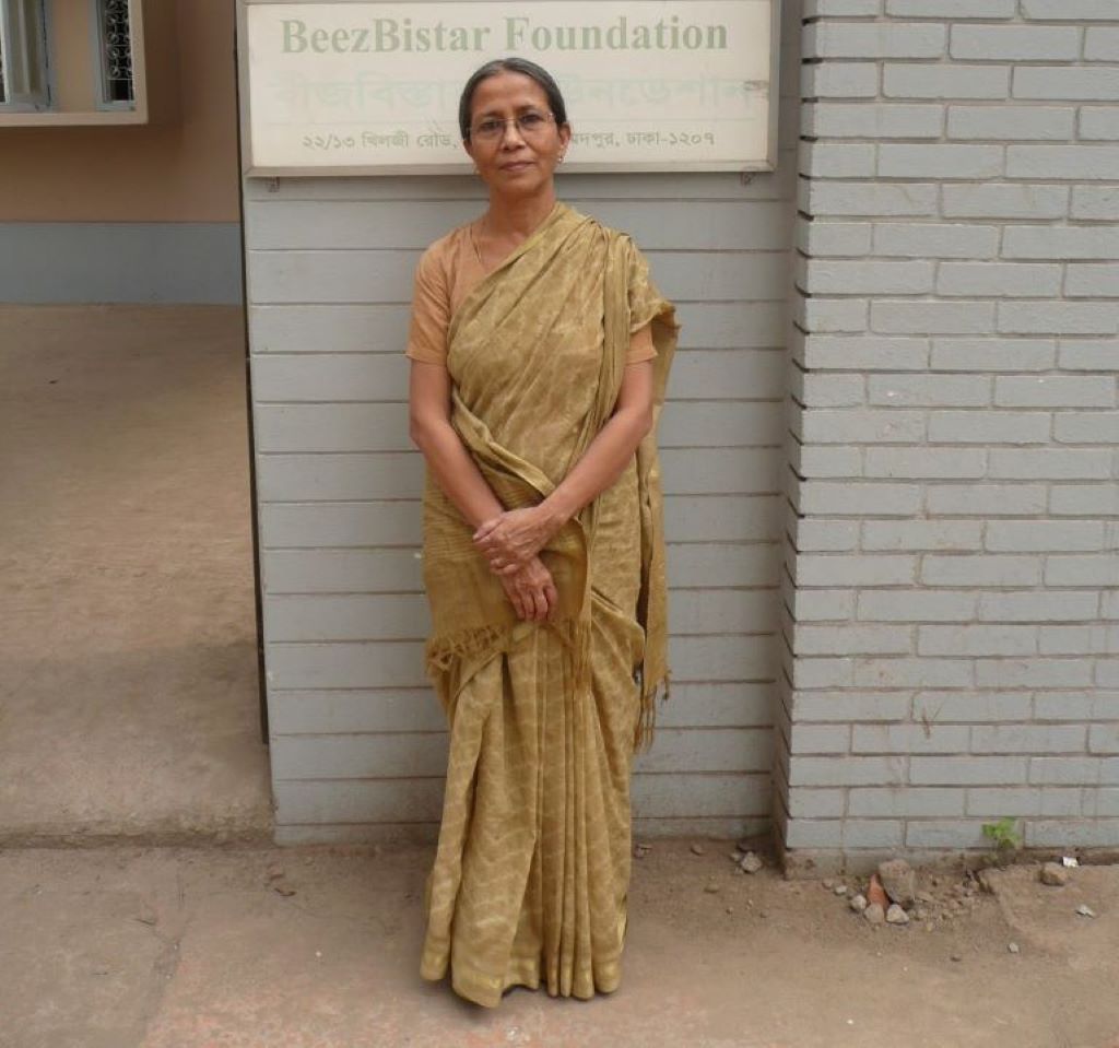 Bangladeshi women's rights activist Farida Akther stands against a wall next to a doorway