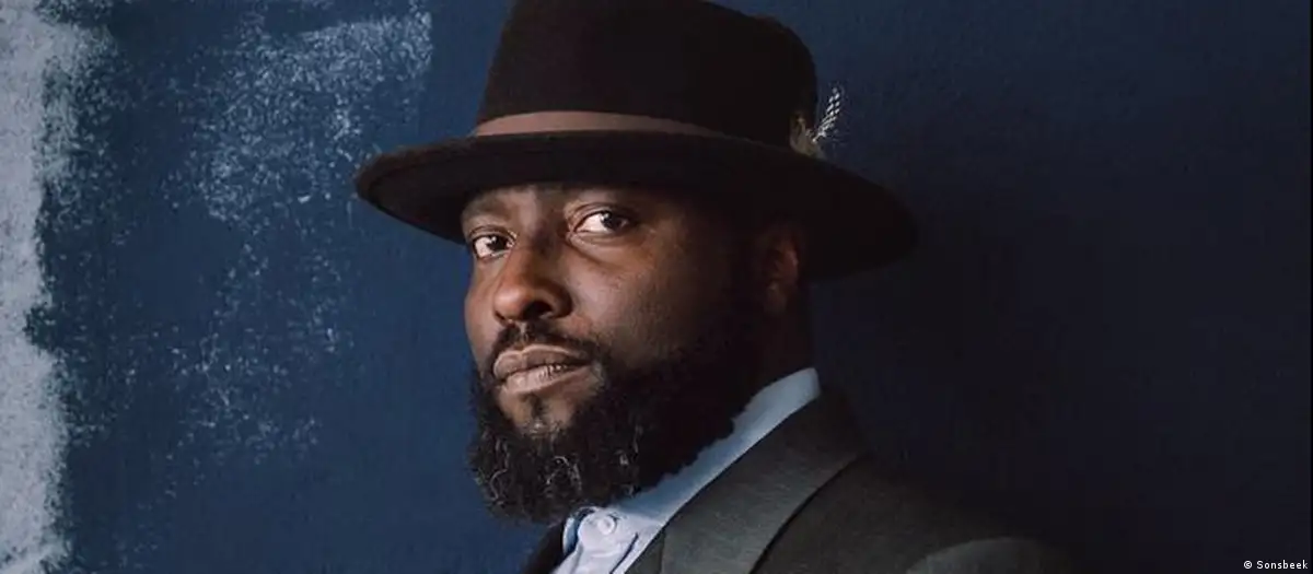 Headshot of curator Bonaventura Ndikung wearing a hat