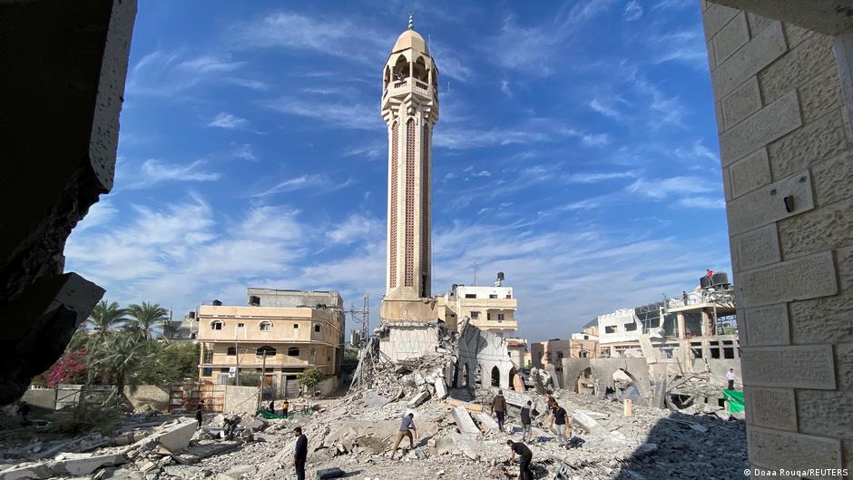 People remove rubble near a mosque destroyed by Israeli airstrikes in Gaza