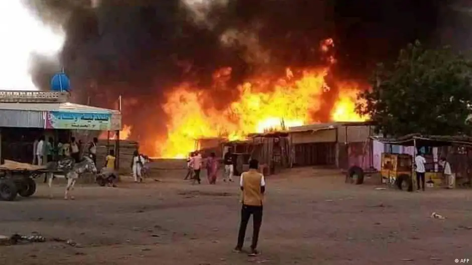   حرب مدمرة في السودان  أسفرت عن مقتل الآلاف وتشريد الملايين image: AFP Man watches as fire rages in the market area of al-Fasher, capital of North Darfur state