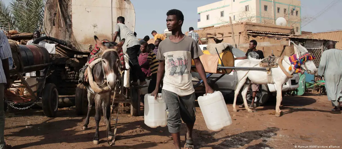 كارثة إنسانية منسية: خلال فترة استراحة قصيرة من الحرب، يتزود الناس في السودان بالمياه في نهاية شهر مايو / أيار 2023. صورة من: Marwan Ali/AP/picture alliance Während einer kurzen Kriegspause Ende Mai: Menschen im Sudan versorgen sich mit Wasser.