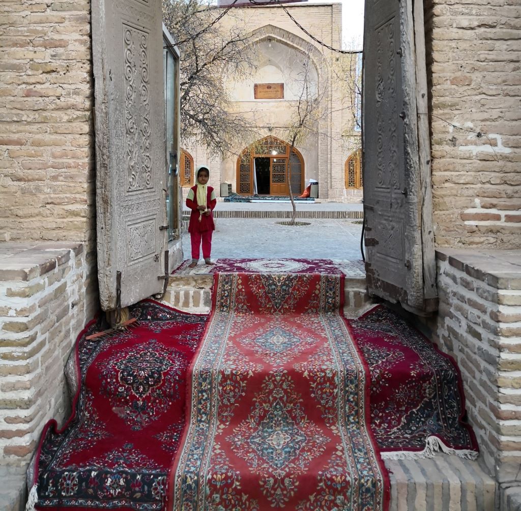 Ein Mädchen wartet an der Türschwelle zum Mausoleum von Sheikh Ahmad e-Dscham in der nordostiranischen Stadt Torbat e-Dscham