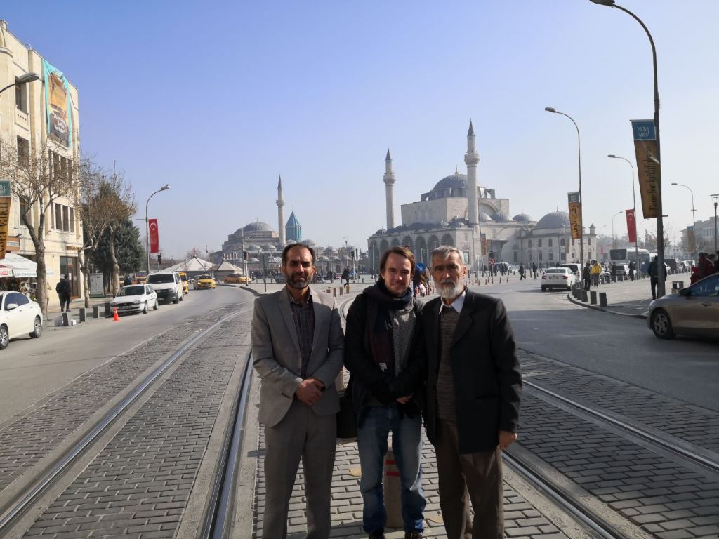 صورة من: Marian Brehmer - الحاج ناصر جامي (على يمين الصورة) يحافظ على تقليد القراءة من مثنوي منذ عقود. هنا في لقاء مع الكاتب الألماني ماريان بريمر (في الوسط) خلال إحياء ذكرى وفاة الرومي في مدينة قونية التركية في ديسمبر / كانون الأول 2019.  Begegnung des Autors mit dem Masnawi-Lehrer Haj Naser Jami (rechts) zur Feier von Rumis Todestag in Konya im Dezember 2019