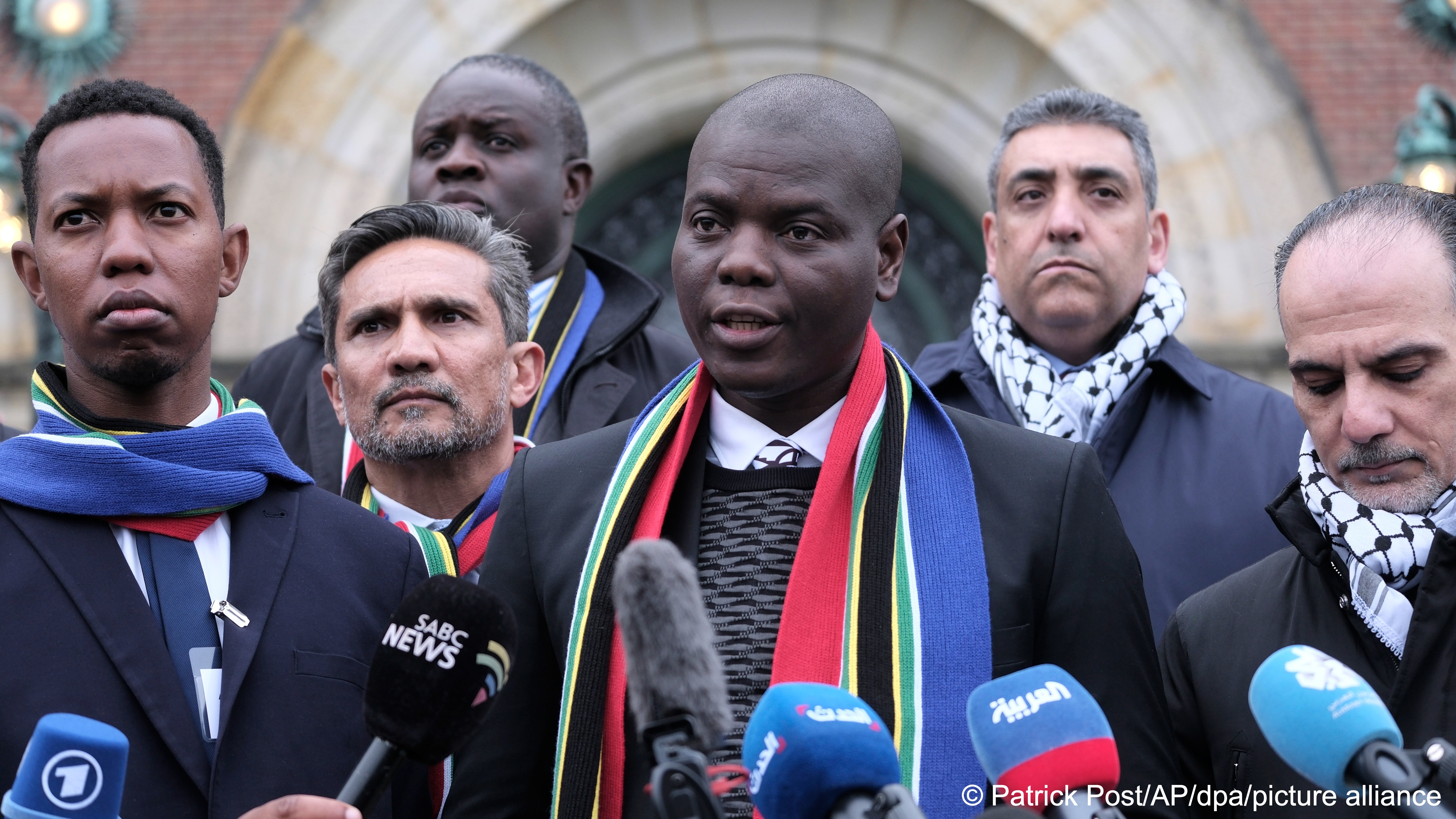 South Africa's Minister of Justice and Correctional Services Ronald Lamola (centre) and Palestinian Assistant Minister of Multilateral Affairs Ammar Hijazi (right) address the media outside the International Court of Justice in the Hague, Netherlands