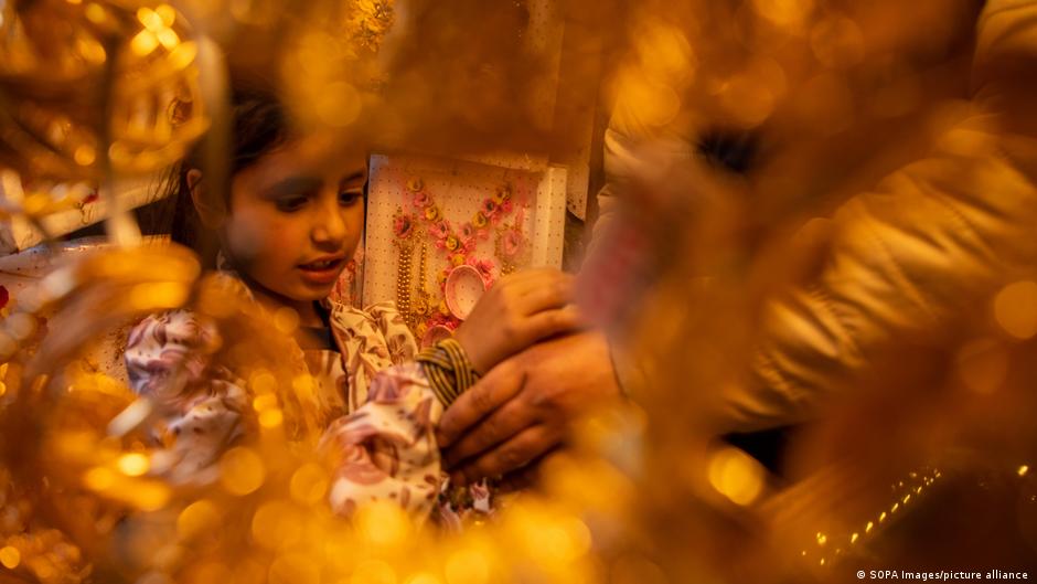 A young girl tries on a bracelet