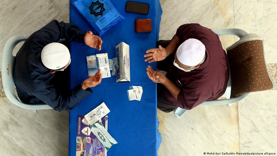 Two men are seen from above, one hands money to the other