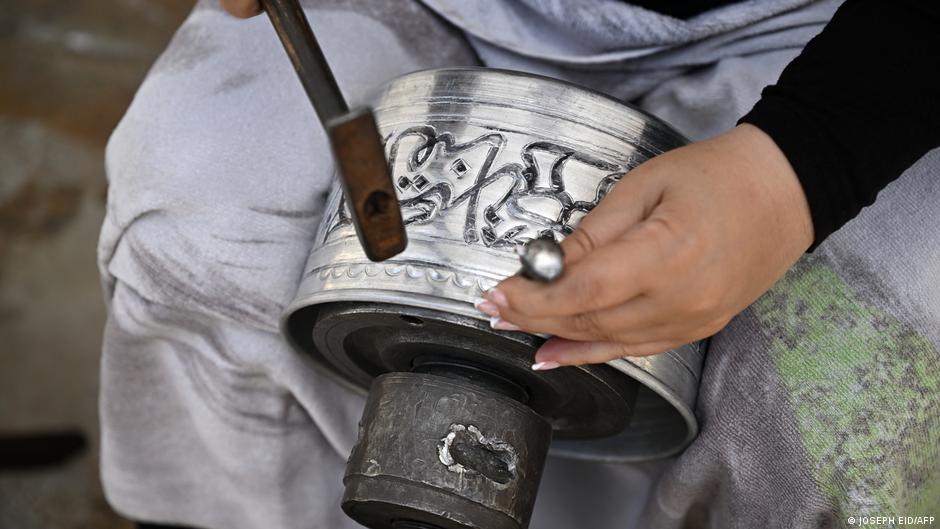 An artisan demonstrates her skills in carving on copper