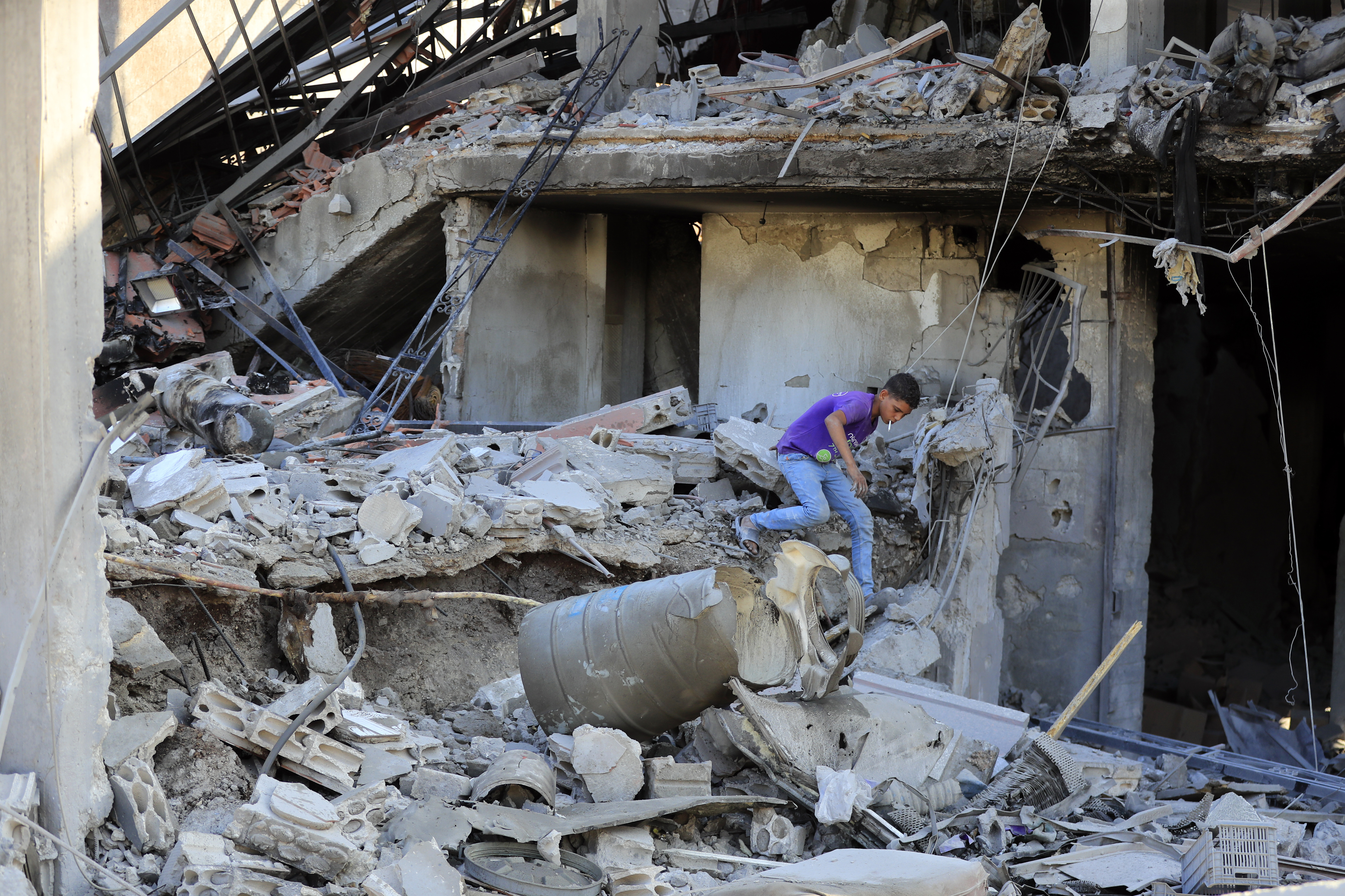 A boy inspects the damage to a building after an Israeli attack in the Lebanese village of Akbieh.