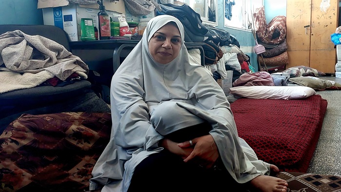 Palestinian woman in hijab sits on the floor