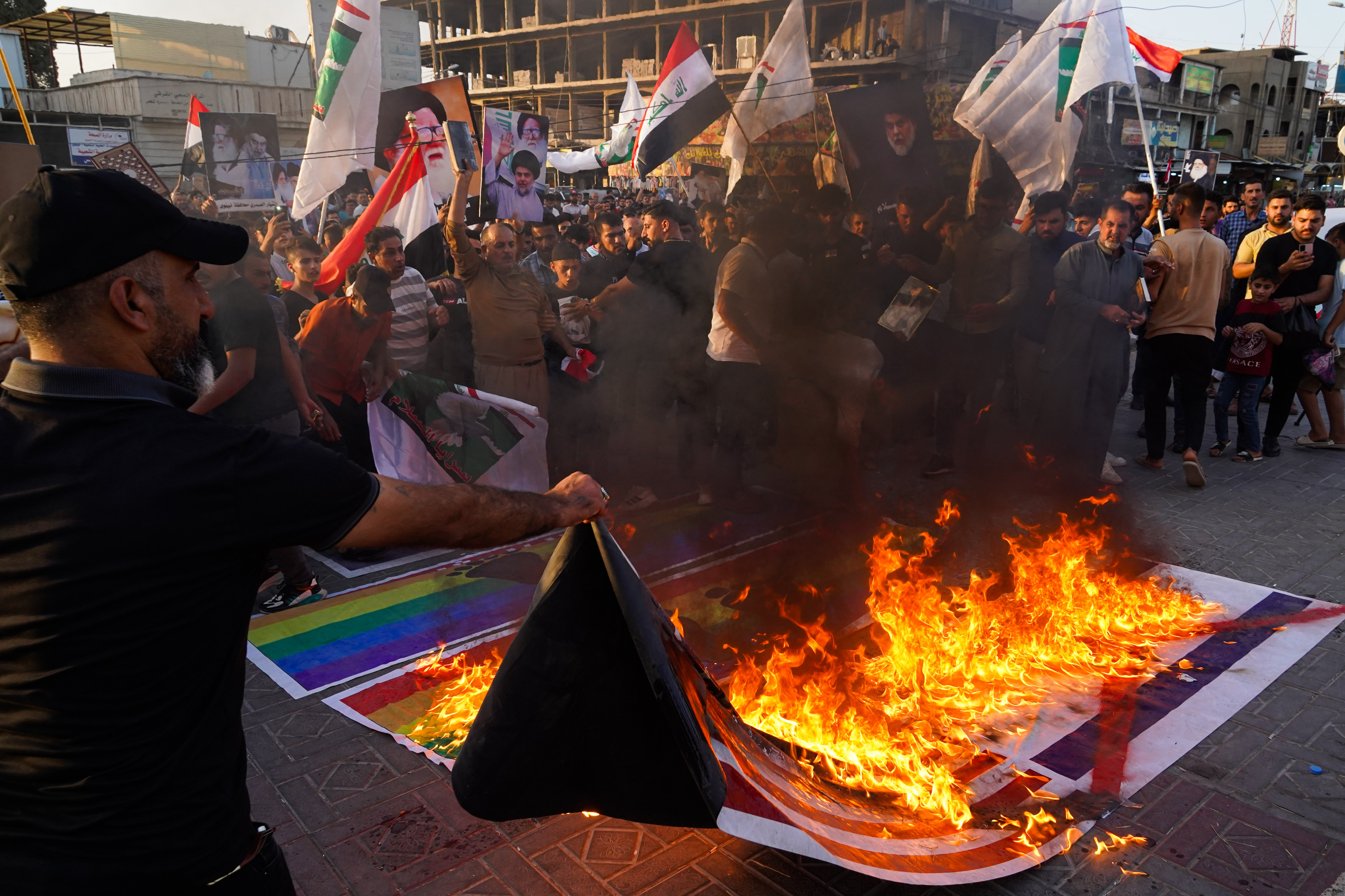 Iraqis protesting, burning American and LGBT flags