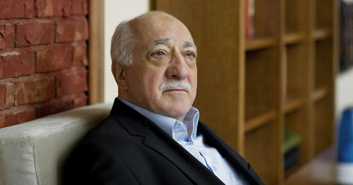 A side profile image of Fethullah Gülen. A bookshelf is visible in the background.