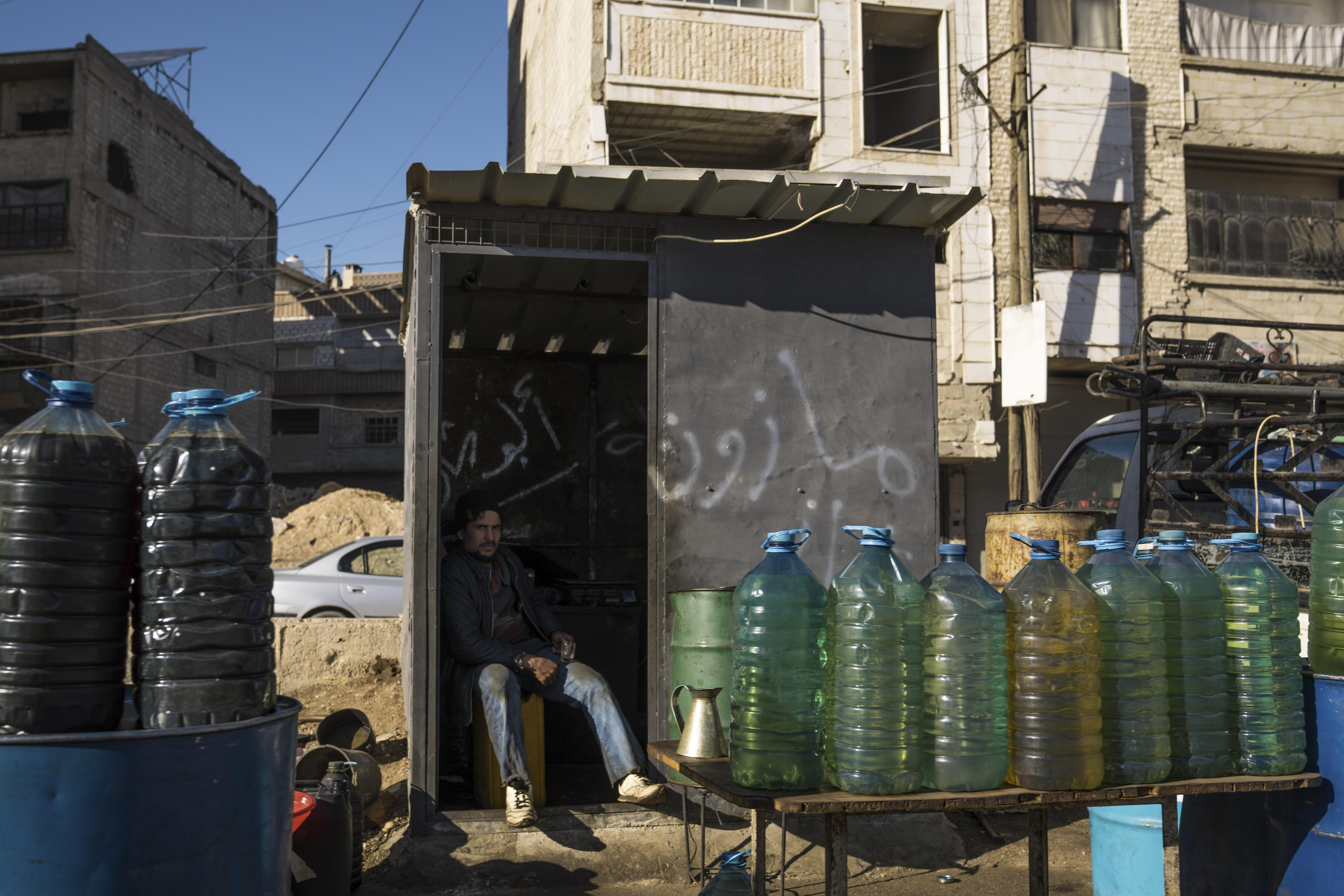 Ein Mann verkauft auf der Straße in Syrien Treibstoff aus Plastikflaschen.