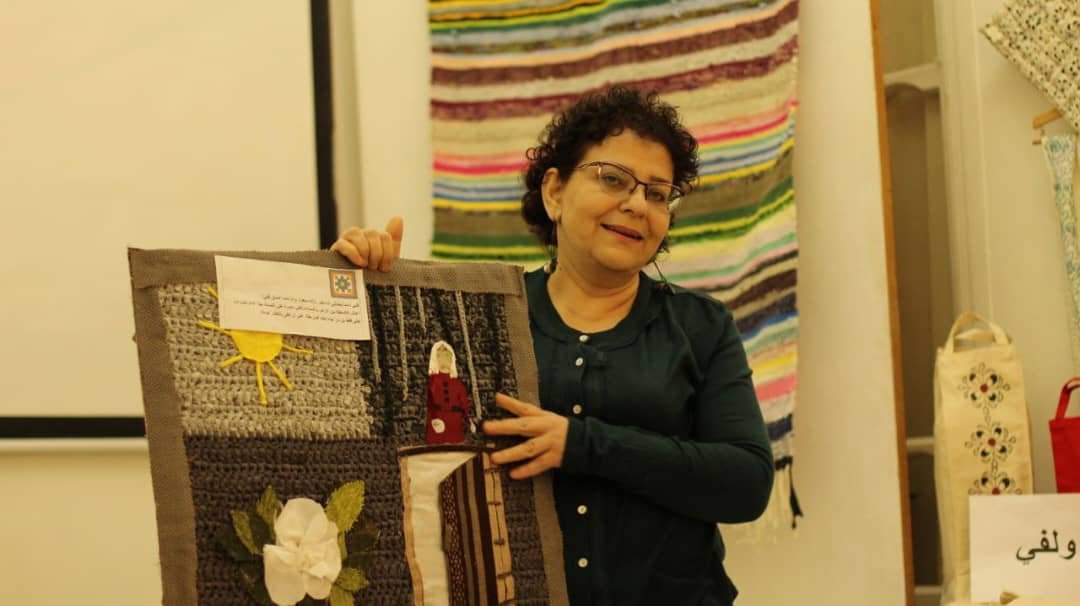 A woman holds a blanket to the camera.