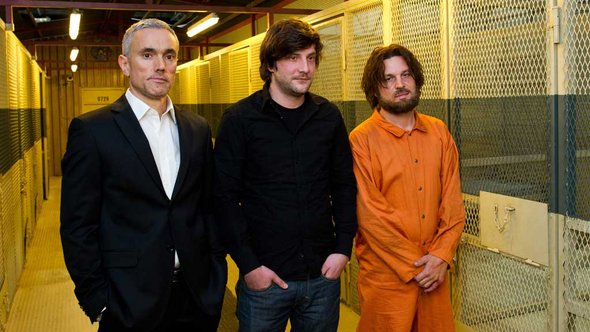 Die Schauspieler Ben Miles (l) als Verhörspezialist Gail Holford, Sascha Alexander Gersak (r) als Guantanamo-Häftling Murat Kurnaz und Regisseur Stefan Schaller; Foto: dpa/picture-alliance