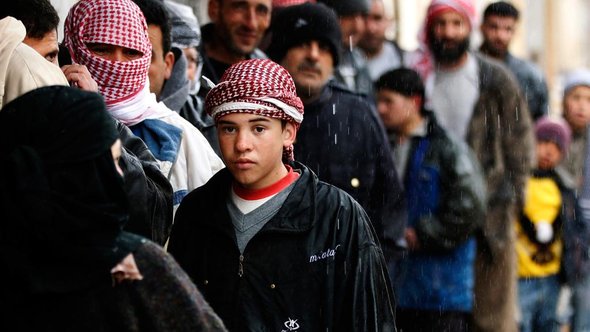 Standing in line for food in front of a bakery, Al Qusayr, western Syria (photo: REUTERS/Goran Tomasevic)