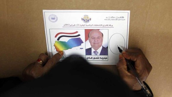 A Yemeni woman fills out a ballot paper in a polling station in Aden (photo: Reuters)