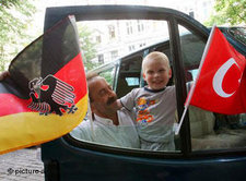 Türkische Zuwanderer schwenken deutsche und türkische Fahnen, Foto: dpa