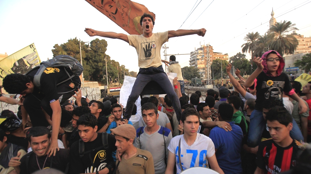 Supporters of the Muslim Brotherhood and ousted Egyptian President Mohamed Mursi shout slogans against the military and interior ministry, during a protest in front of barbed wire, army soldiers and the riot police at El-Thadiya presidential palace in Cairo, November 15, 2013 (photo: Reuters/Amr Abdallah Dalsh)