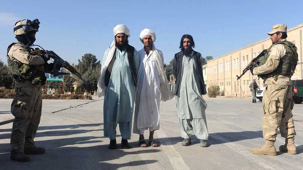 Afghan security forces guard captured Taliban fighters as they are presented to the media in Herat on January 24, 2013 (photo: Aref Karimi/AFP/Getty Images)