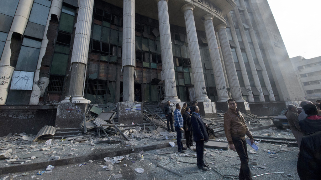 Ägypter stehen vor dem Gerichtsgebäude, auf das am Morgen der Wahl über eine neue ägyptischen Verfassung ein Anschlag verübt wurde, Kairo, 14. Januar 2014; Foto: Khaled Desouki/AFP/Getty Images