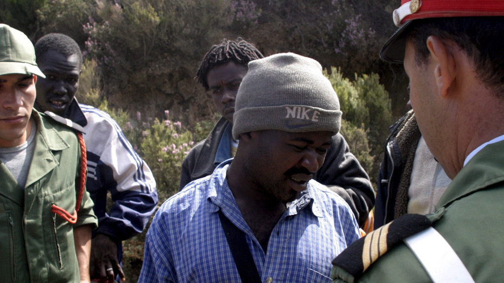 Moroccan gendarmes detain would-be-immigrants trying to cross the razor-wired fences separating Morocco and Spain's North African enclave of Ceuta in Bel Youmeech forest, Morocco (photo: picture-alliance/dpa/dpaweb)