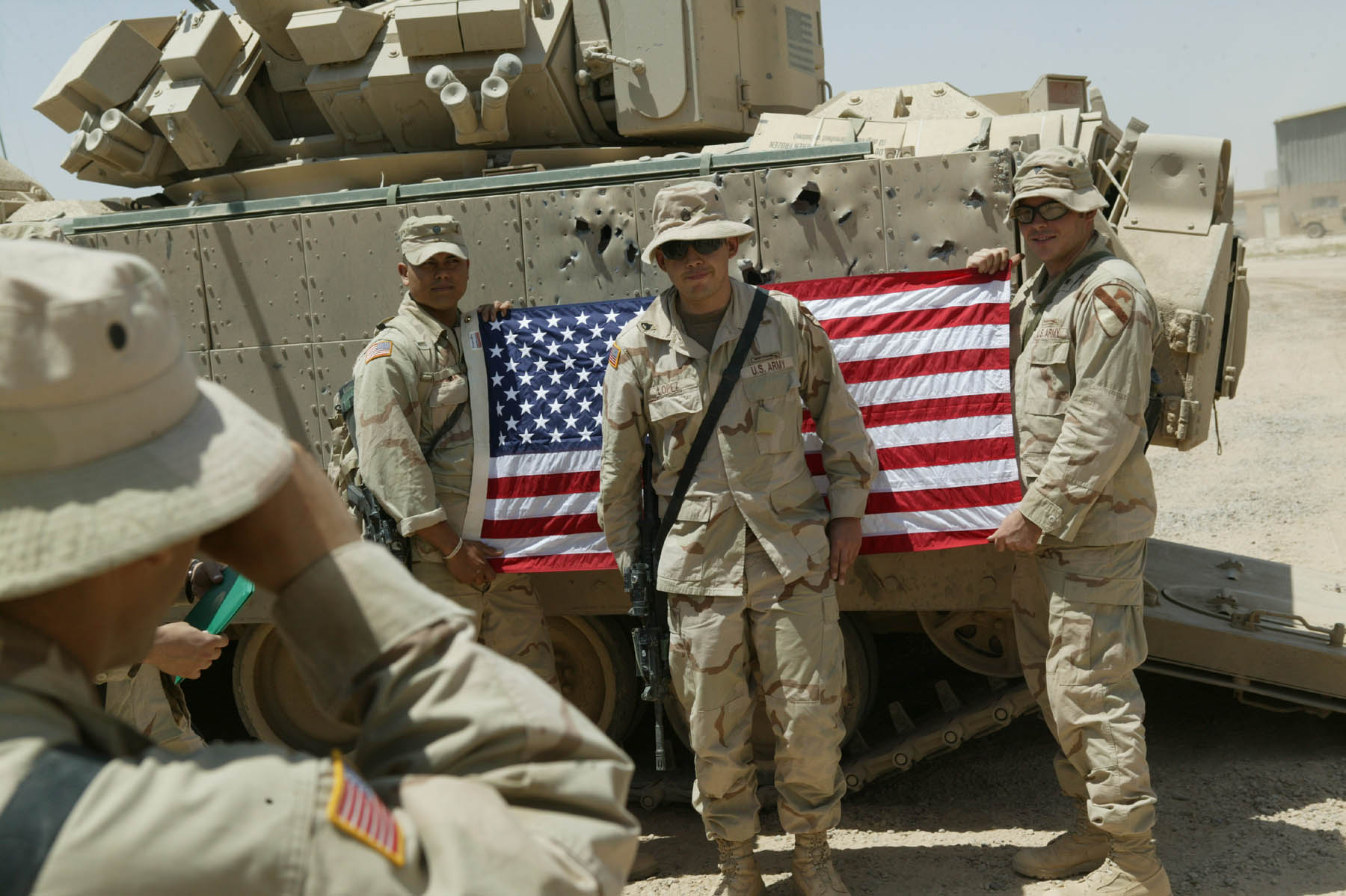 A US soldier has his picture taken in front of the US flag at his re-enlistment ceremony (photo: Michael Kamber) 