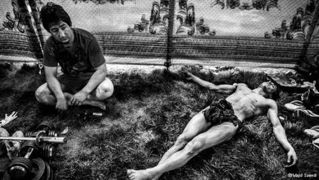 An Afghan weightlifter resting after competition. The weights can be seen in the corner of the photo (photo: Majid Saeedi)