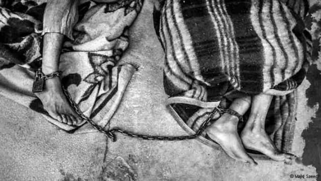 Two people chained together at the ankles (photo: Majid Saeedi)