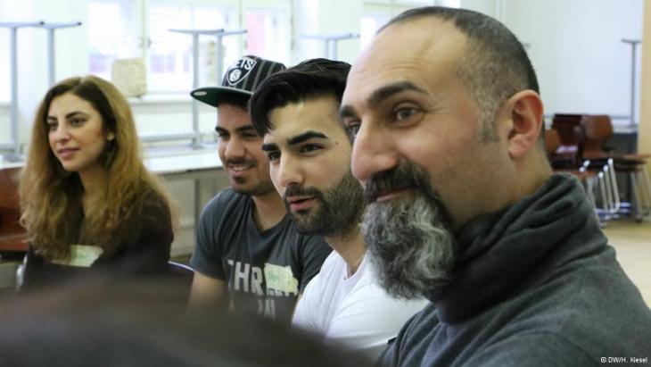 Theatre pedagogue Yilmaz Atmaca (right) listens attentively to a group of young people (photo: DW/H. Kiesel)