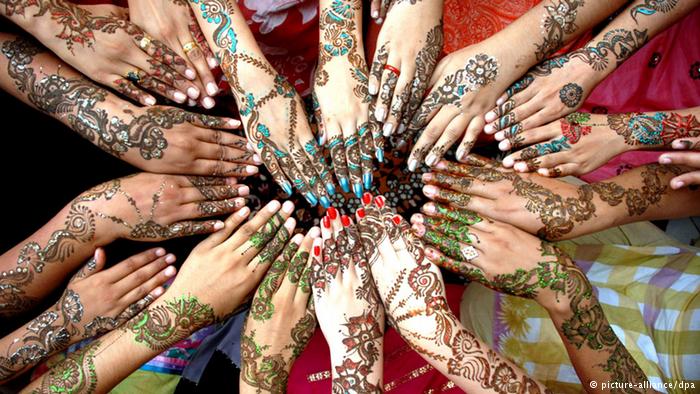 A circle of 17 hands painted with henna in different colours. Photo: picture alliance/dpa