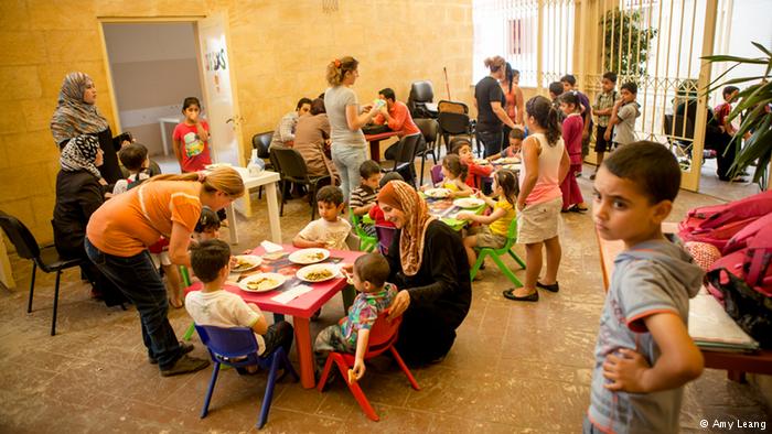 Syrische Schüler beim Mittagessen in einem Hof; Foto: Amy Leang