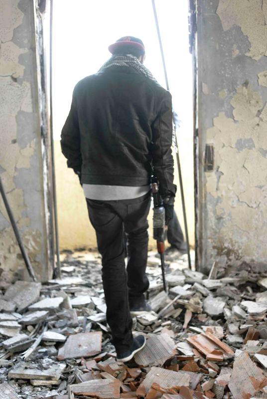 A young tribal fighter assessing a building destroyed in Warshefana (photo: Valerie Stocker) 