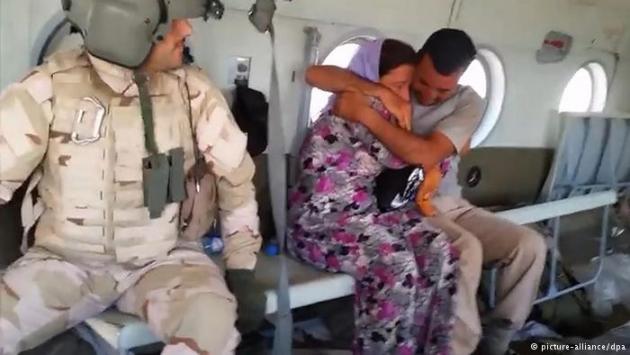 A Yazidi man and women being airlifted to safety (photo: picture-alliance/dpa)