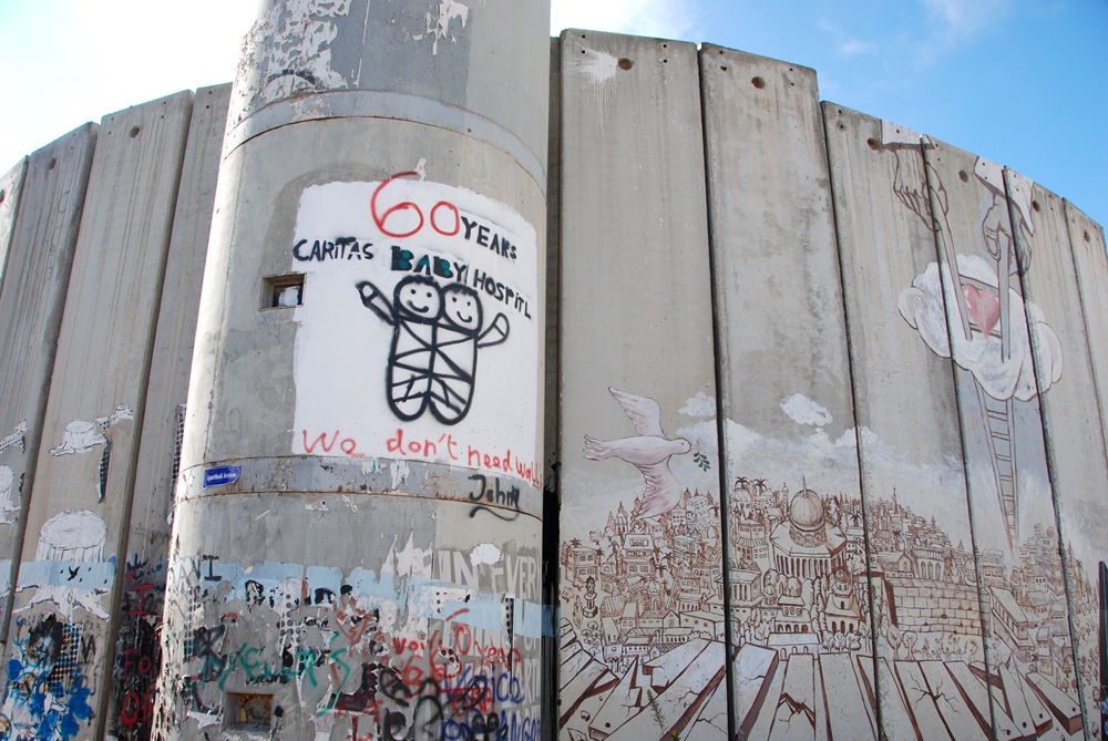 Gruß des Caritas Baby-Krankenhauses (Mitte) sowie eine Darstellung Jerusalems mit gefallener Mauer, Friedenstaube und Gottes Liebe, dargestellt durch eine Leiter die sich aus dem Himmel herabsenkt; Foto: Laura Overmeyer