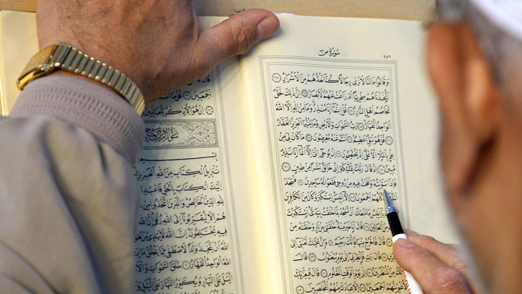 Mann liest im Koran; Foto: picture-alliance/ dpa