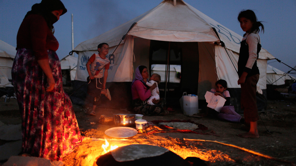 A Yazidi woman, who fled violence in the Iraqi town of Sinjar, makes bread at Bajed Kadal refugee camp in Dohuk province, 22 August 2014 (photo: Reuters/Youssef Boudlal)