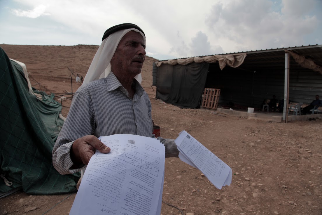 Mahmoud Awwad Ayoub holding notification from the IDF ordering him to leave, Al-Maleh, West Bank, October 2014 (photo: Mohammad Alhaj)