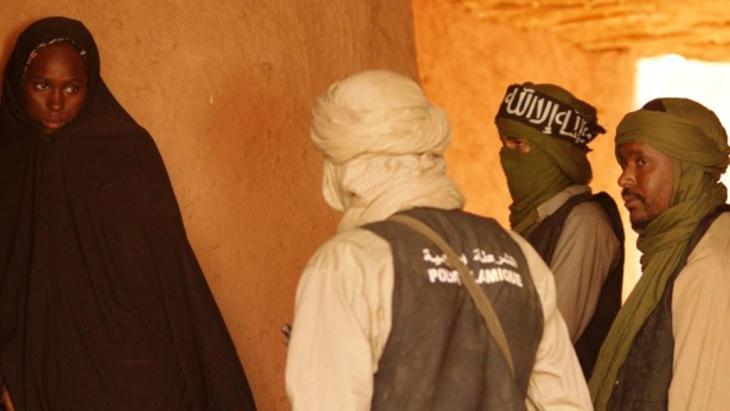 Face to face with the new order: a woman in a chador faces three jihadis. Still frame from Abderrahmane Sissako's film "Timbuktu"