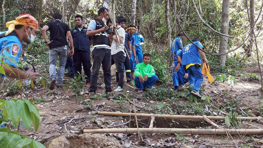 Rescue workers and forensic officials inspect the site of a mass grave (photo: AFP/Getty Images/Str)