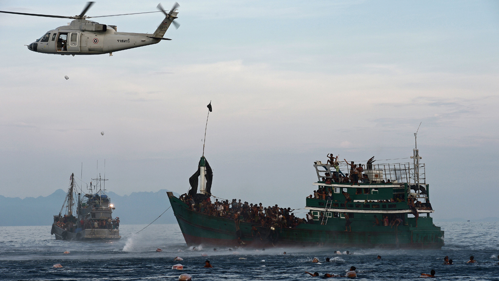 Rohingya migrants swim to collect food supplies dropped by a Thai army helicopter (photo: Getty Images/Afp/C. Archambault) 