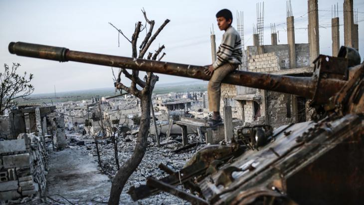 A boy sitting on a tank gun, Ain al-Arab, Syria (photo: Getty Images/AFP/Y. Akgul)