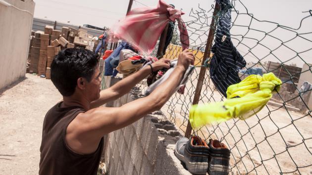 Foreign worker hanging up laundry, Qatar (photo: Sam Tarling)