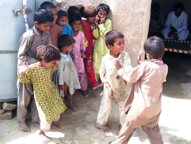 Children watch as two young boys play (photo: Usman Mahar)