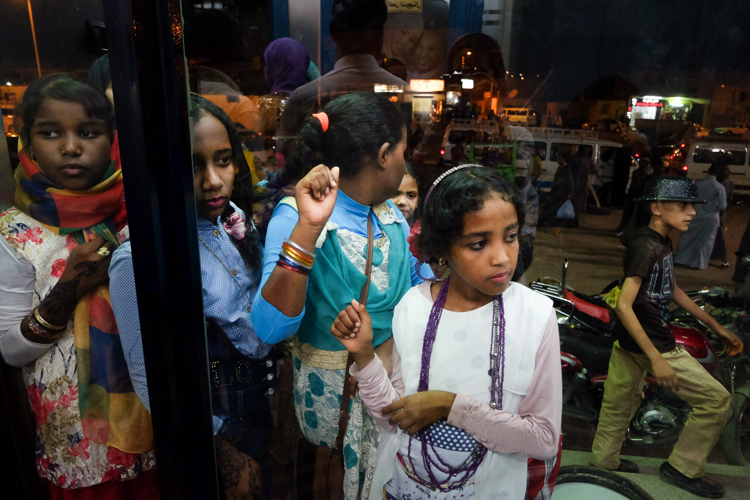 Teenage girls peer into a photography studio in Aswan (photo: Maya Hautefeuille)