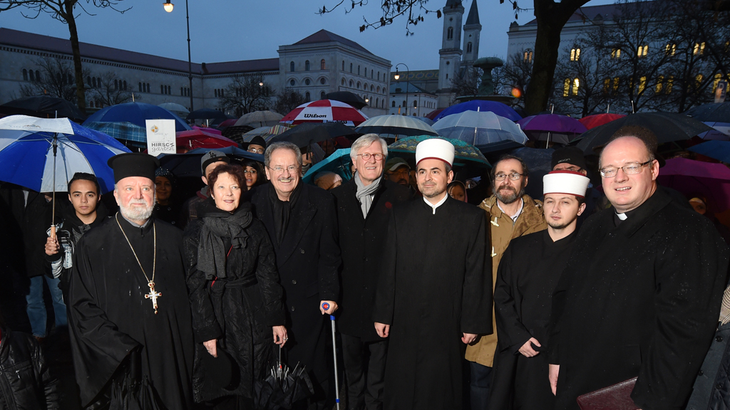 Gemeinsam gegen den Extremismus und Gewalt: Der orthodoxe Erzpriester Apostolos Malamoussis (l-r), die Stadtdekanin Barbara Kittelberger, der frühere Münchner Oberbürgermeister Christian Ude (SPD), der Landesbischof der Evangelisch-Lutherischen Kirche in Bayern, Heinrich Bedford-Strohm, der Imam Benjamin Idriz, Jan Mühlstein von der liberalen jüdischen Gemeinde, der Imam Belmin Mehic, und der Bischofsvikar des Erzbistums München und Freising, Rupert Graf zu Stolberg, stehen am in München bei einer Kundgebung zusammen, das das "Münchner Forum für Islam" unter dem Titel "Steh auf gegen Hass und Gewalt" veranstaltet; Foto: Tobias Hase/dpa