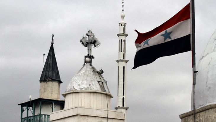 A Syrian flag flies alongside the Saint Sarkis Church in Damascus (photo: Getty Images/LOUAI BESHARA)