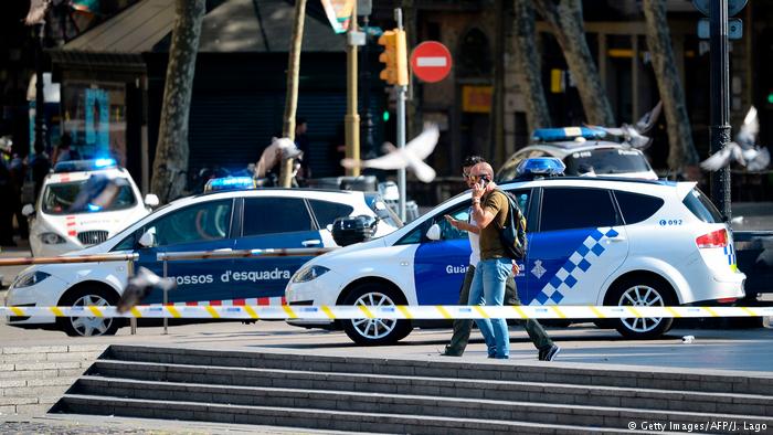 Police phone as they walk past police cars