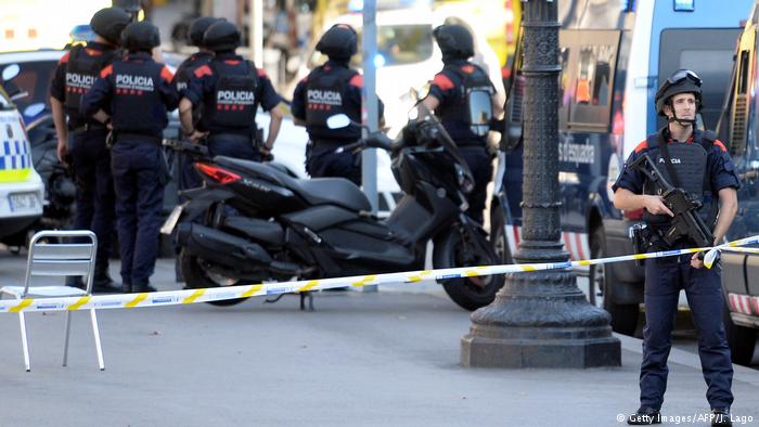 Armed policemen stand in a cordoned-off area