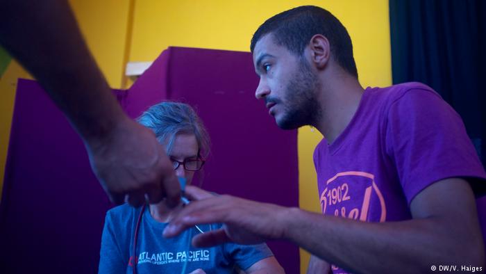 A doctor checks a man's pulse during a health clinic