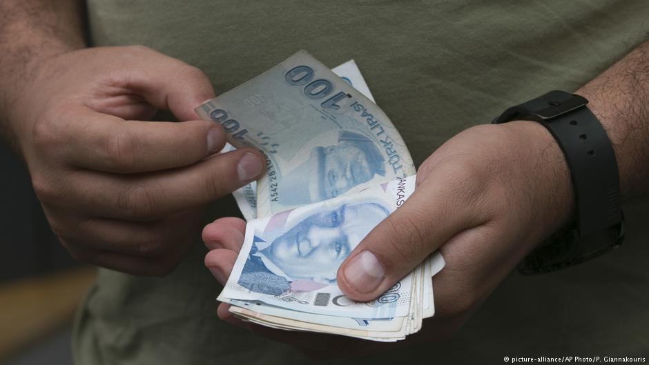 A man counts his Turkish liras as he leaves a currency shop in central Istanbul (photo: picture-alliance/AP Photo/P. Giannakouris) 